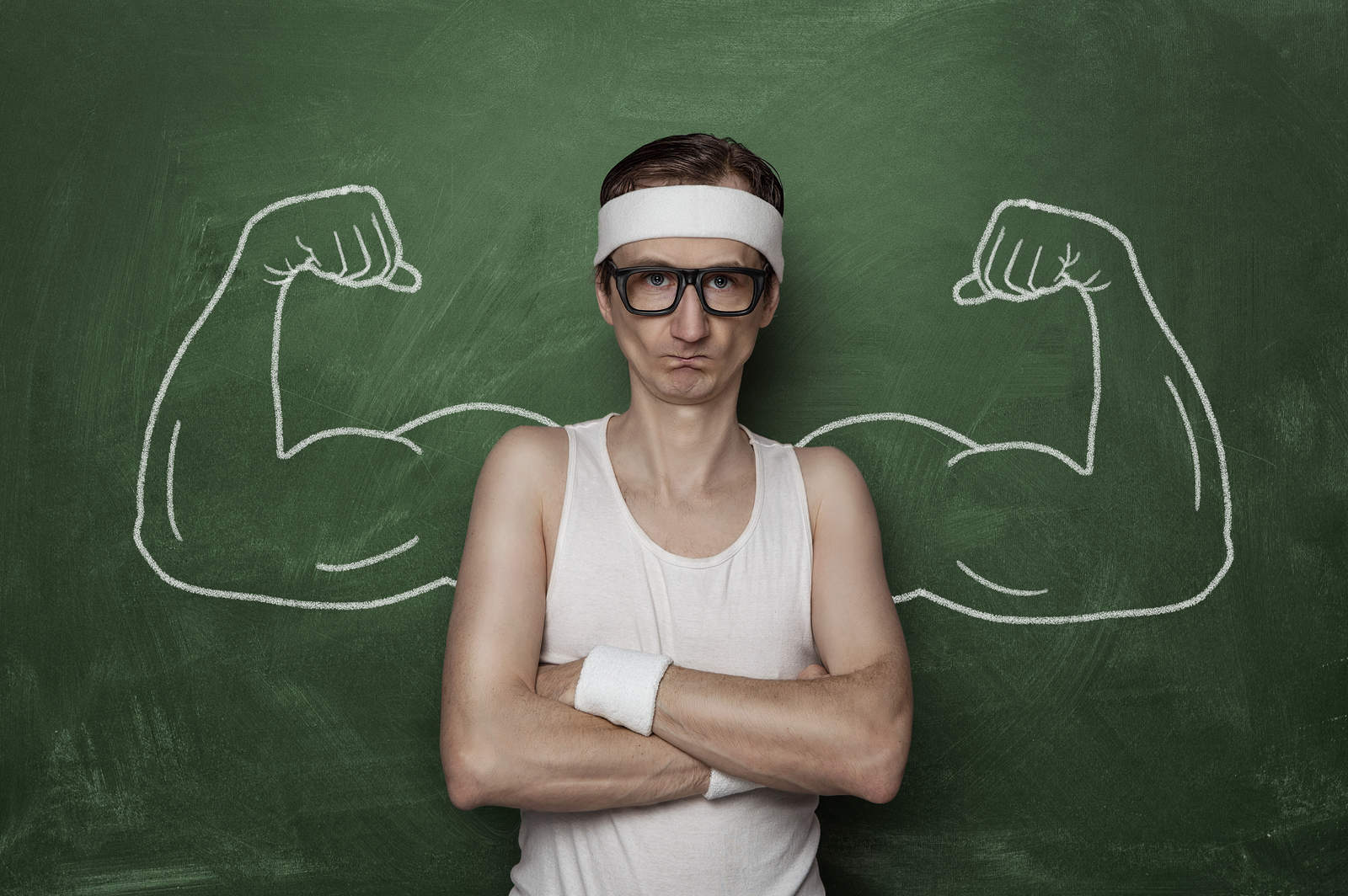 Skinny man with fake muscles drawn on the chalkboard